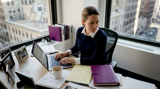 Director typing marketing memo in corner office